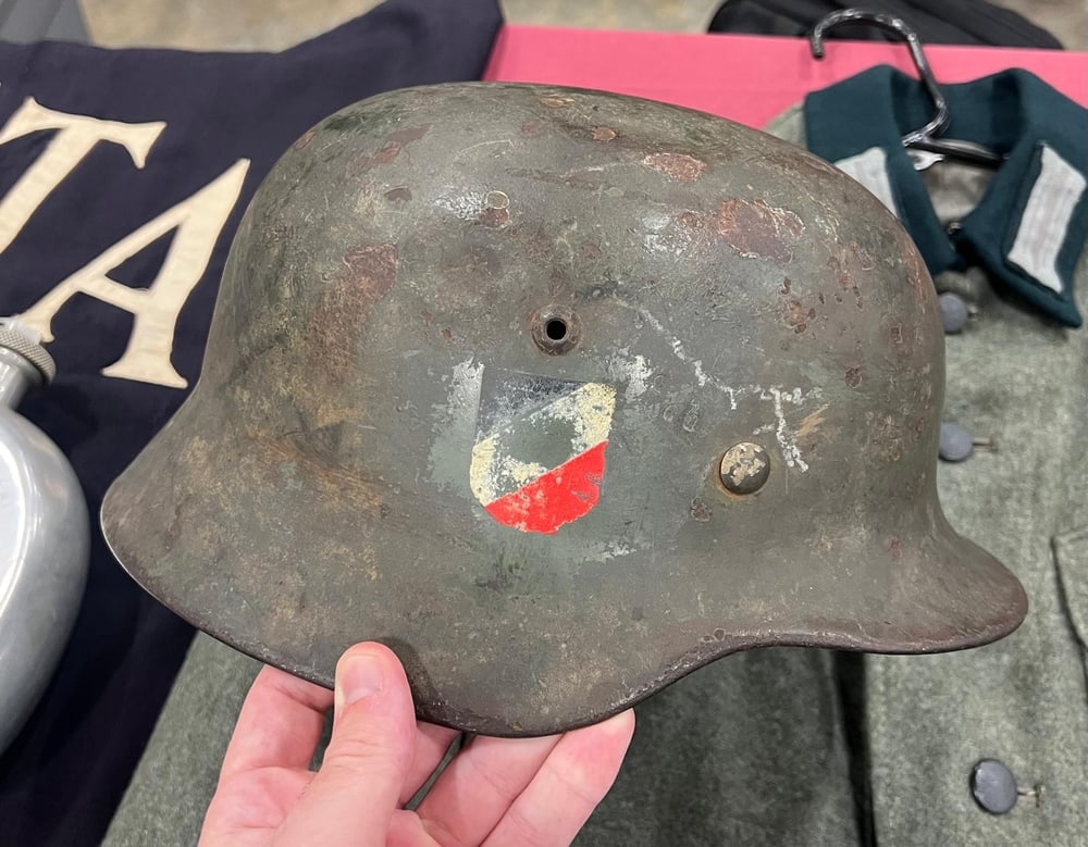 Stahlhelm M42 aus dem Zweiten Weltkrieg mit nur einem Abzeichen, dem Wappenschild in Schwarz-Weiß-Rot, und stark abgetragenem Originallack.