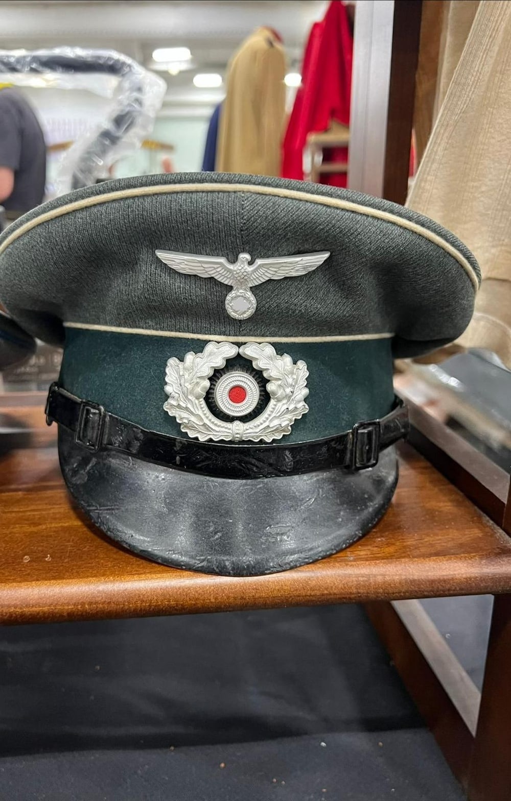 Schirmmütze des Heeres, Infanterie (weiße Paspel), mit Eichenlaubkranz und Kokarde. Das Symbol am Adler ist unkenntlich gemacht (§ 86a StGB).