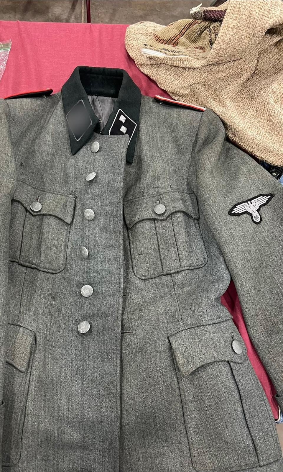 Guerrera de las Waffen-SS de la Segunda Guerra Mundial, en paño italiano, con el águila en la manga y hombreras con vivo rojo. El parche de cuello va tapado (§ 86a StGB).
