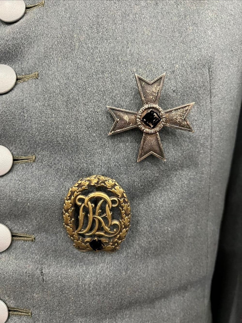 Kriegsverdienstkreuz 1. Klasse ohne Schwerter und Deutsches Reichssportabzeichen (DRL), an der Feldbluse getragen. Symbole unkenntlich gemacht (§ 86a StGB).