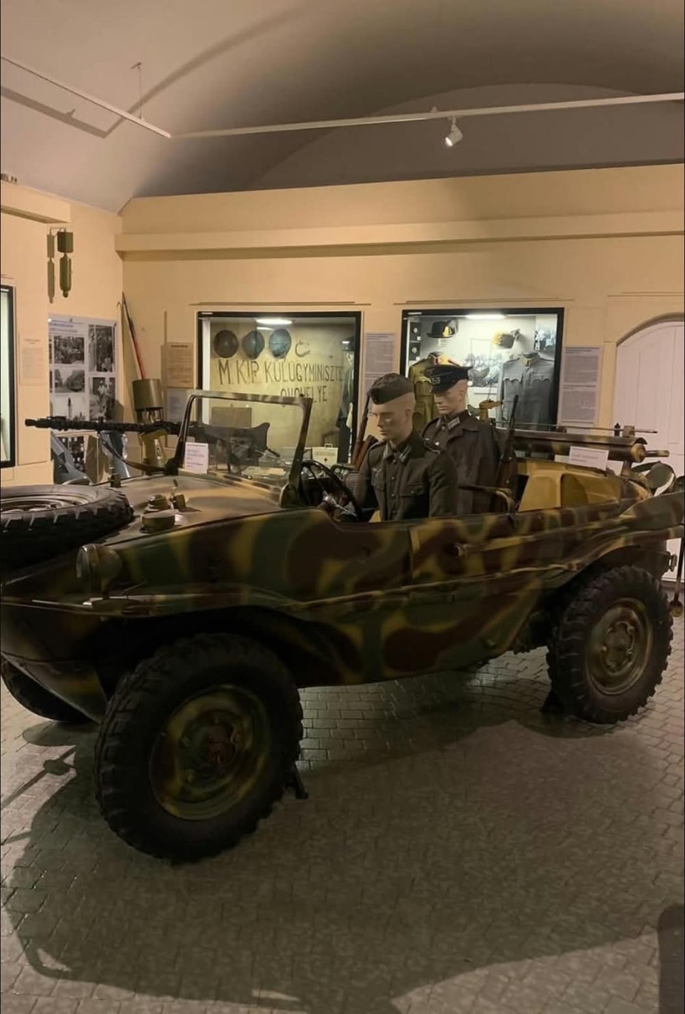 Schwimmwagen im Tarnanstrich, mit Ersatzrad auf der Haube und MG-Halterung.